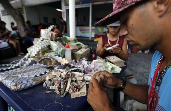 Tờ tiền có giá ngang tờ giấy vụn được người dân venezuela gấp thành túi xách bán cho khách du lịch - 2