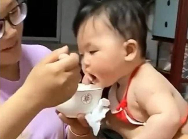 Bé gái yếm đỏ mũm mĩm đốn tim nhiều người vì háu ăn giật cả bát từ tay mẹ - 1
