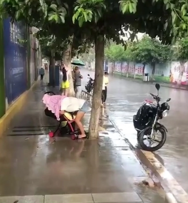 Trời mưa tầm tã hành động của mẹ trẻ làm người qua đường ai cũng ngoái lại nhìn - 2