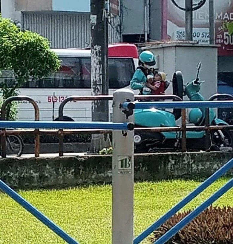 Sài gòn nắng nóng 40 độ nữ shipper đứng giữa đường cho con bú khiến nhiều người thấy thương - 1