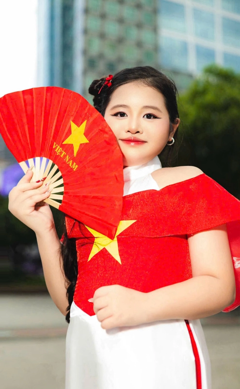 Mẫu nhí dory như tỏa sáng trong tà áo dài đỏ sao vàng mừng 29 - 2